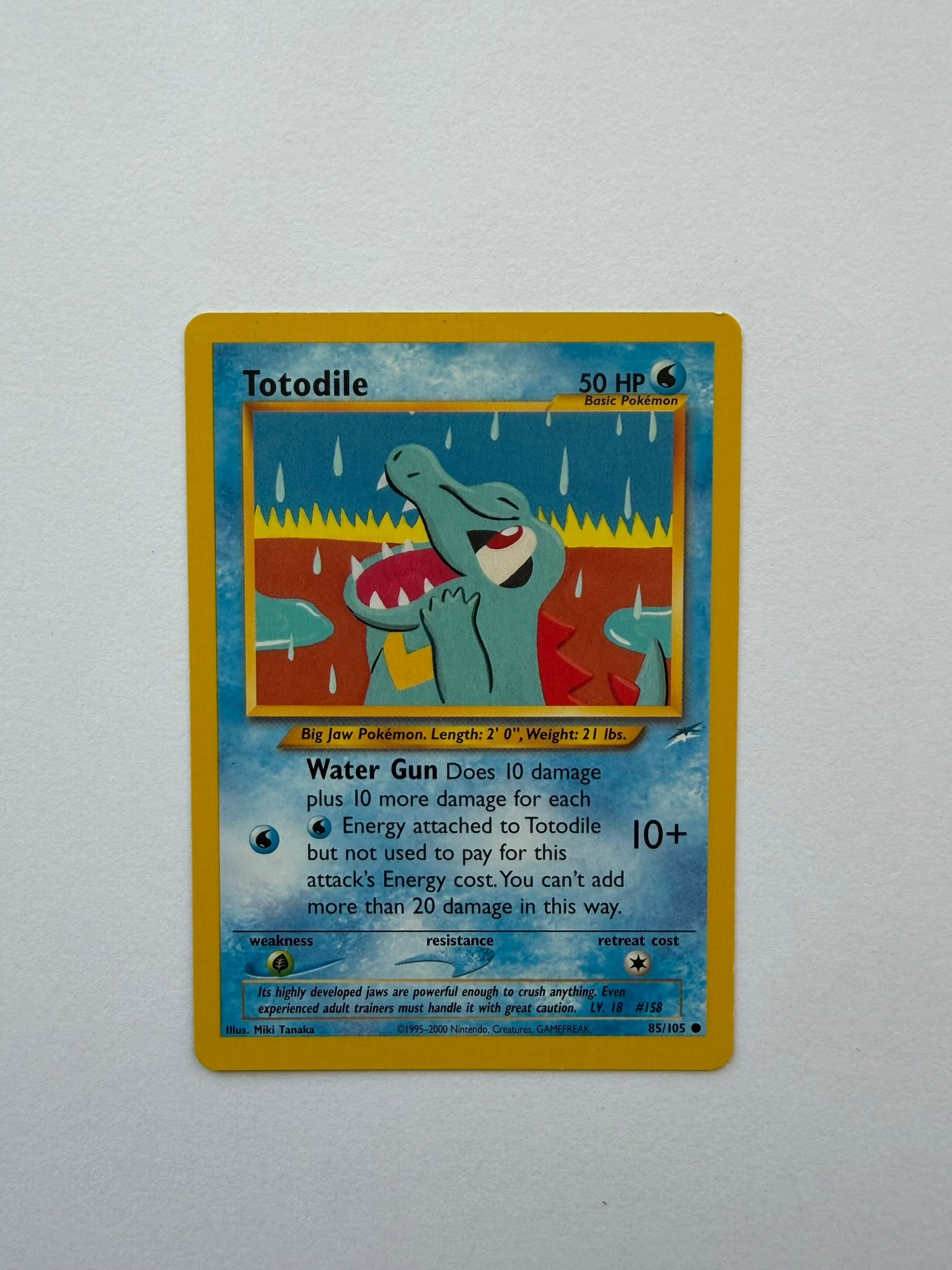 2002 Pokemon Totodile 85/105 Neo Destiny: Vintage Totodile 85/105 from the 2002 Pokemon Neo Destiny expansion. Unlimited non-holo common featuring colorful Miki Tanaka artwork. Ungraded with visible age-related edge and surface wear. Please r