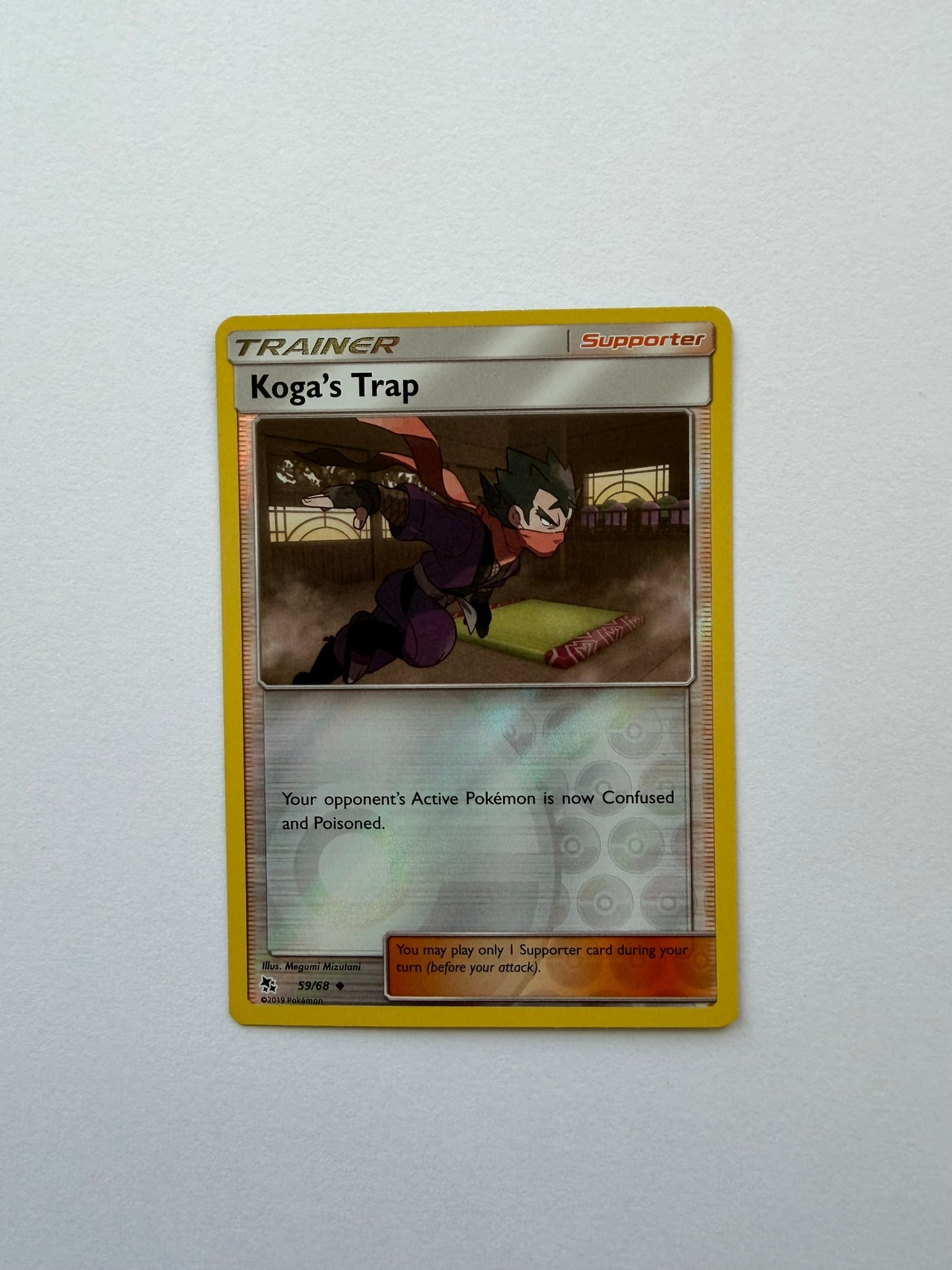 2019 Pokemon Koga's Trap 59/68 Hidden Fates Reverse Holo: Koga's Trap 59/68 reverse-holo Supporter card from the 2019 Pokemon Hidden Fates expansion. Features dynamic Megumi Mizutani artwork. Ungraded with visible edge and surface wear. Please review photogr