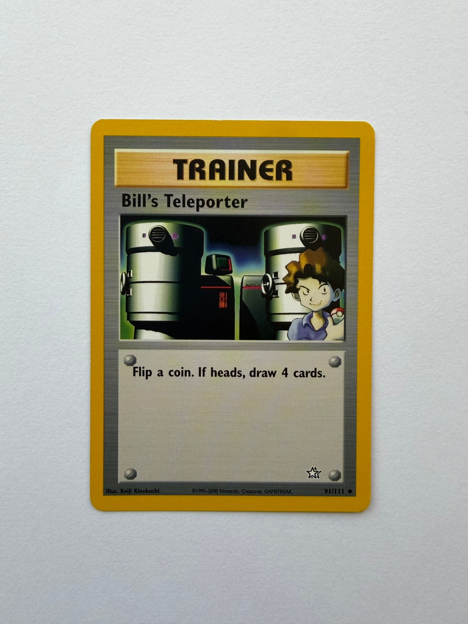 2000 Pokemon Bill's Teleporter 91/111 Neo Genesis: Bill's Teleporter 91/111 Trainer card from the 2000 Pokemon Neo Genesis expansion. Unlimited non-holo uncommon featuring artwork by Keiji Kinebuchi. Ungraded with visible edge and surface wear. Please