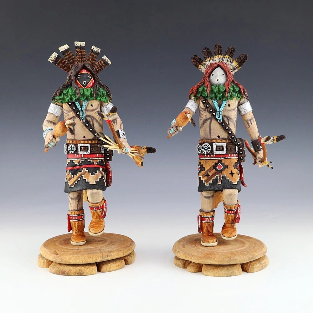 Lawrence Jacquez Navajo Twin Warriors Folk Art Figures: Pair of hand-carved Navajo folk art figures by Lawrence Jacquez, depicting Born for Water and Monster Slayer from the Hero Twins tradition. The detailed cottonwood sculptures feature painted clothing,