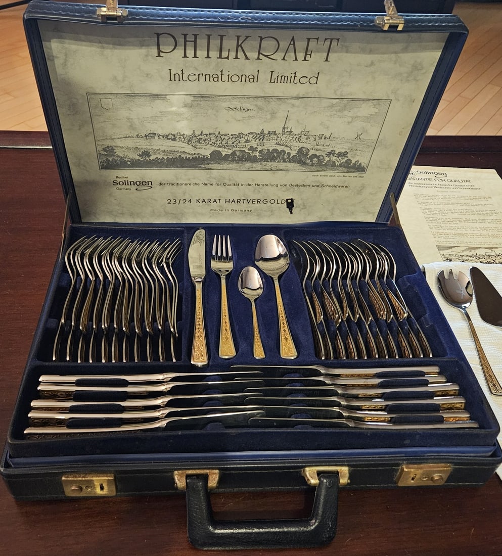Philkraft Solingen 70-Piece 23/24K Gold-Plated Flatware Set with Case: Philkraft International Limited Solingen 70-piece flatware set made in Germany, featuring 23/24-karat hard gold plating over 18/10 stainless steel. The set includes table and serving utensils, includi