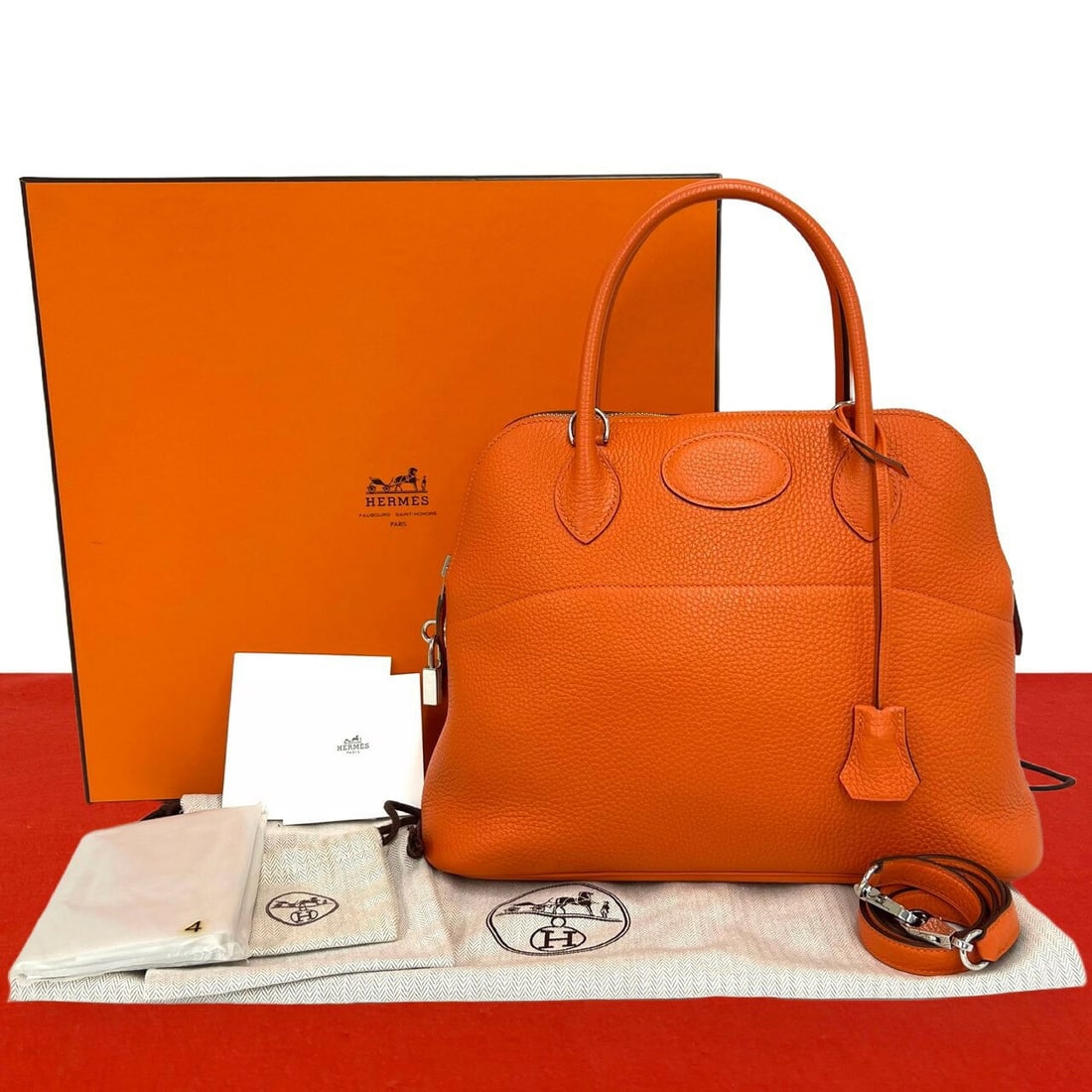 Hermès Bolide 31 Orange Taurillon Clemence Leather Handbag: Hermès Bolide 31 handbag in orange Taurillon Clemence leather. The bag features rolled top handles, a zip-top closure, a detachable shoulder strap, padlock and clochette details, and silver-tone hard