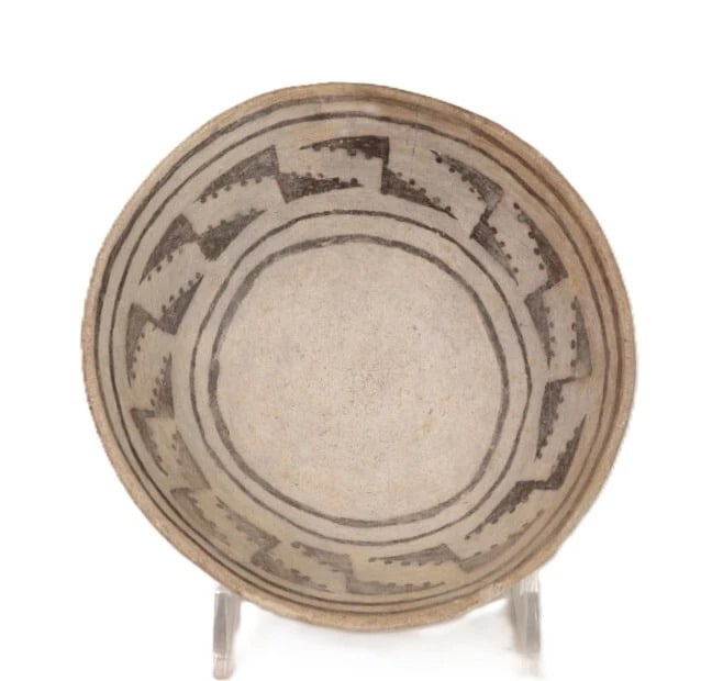 Anasazi Black-on-White Pottery Bowl, A.D. 1000-1300: An Anasazi black-on-white pottery bowl dating to A.D. 1000-1300. The interior features concentric bands and a geometric triangular motif accented with rows of dots. The exterior is largely undecorated