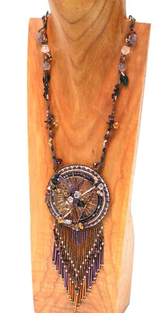 Medallion Beaded Necklace 21 in; 3 1/2 in medallion, + 4 in fringe: Medallion Beaded Necklace 21 in; 3 1/2 in medallion, + 4 in fringe. Medallion Beaded Necklace Late 20th Century ca 1960 21 in length; 3 1/2 in medallion, + 4 in fringe An unusual necklace that was par