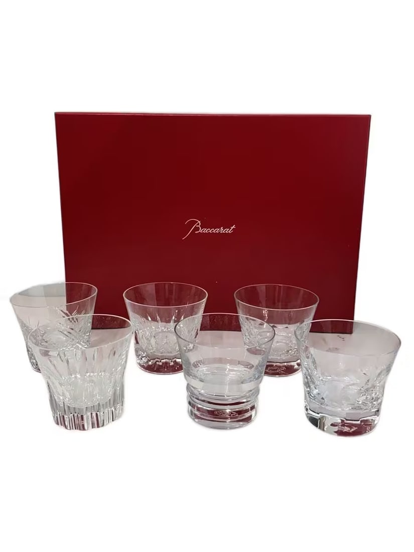 Baccarat Six-Piece Assorted Glass Tumbler Set with Presentation Box: Six-piece Baccarat glass assortment featuring clear tumblers in varied designs, including cut and vertically fluted patterns. The glasses are presented with a red Baccarat-branded presentation box.