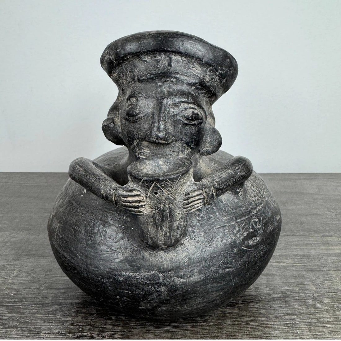 Antique Pre-Columbian Chimu Blackware Pottery Figural Stirrup Spout Vessel Man: Pre-Columbian Antique Chimu style blackware pottery vessel features a striking figural design of a man holding a cup to his mouth. This hand-crafted ceramic piece showcases traditional stirrup spout a