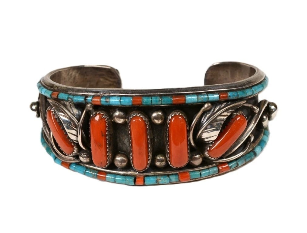 Navajo Sterling Silver Turquoise Heishi Coral Cuff Bracelet, circa 1960: Navajo sterling silver cuff bracelet dating to circa 1960, featuring turquoise and red Mediterranean coral heishi-style inlay with applied silver decoration. The unsigned bracelet has a substantial 1.
