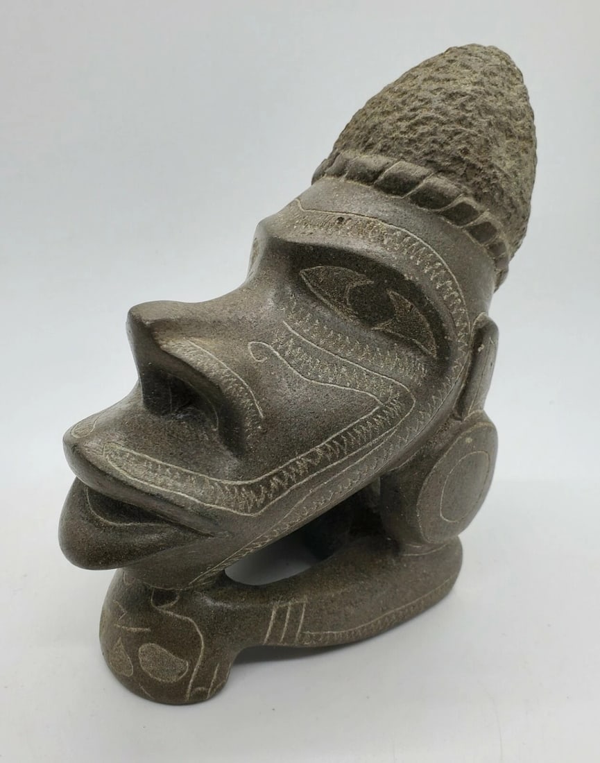Stone Nguzunguzu Canoe Figurehead Idol, Solomon Islands: Carved solid gray stone figure identified as a Nguzunguzu, also known as Toto isu or Musu musu, with additional spellings including Nguzu nguzu, Totoisu, and Musumusu. The form depicts a stylized cano