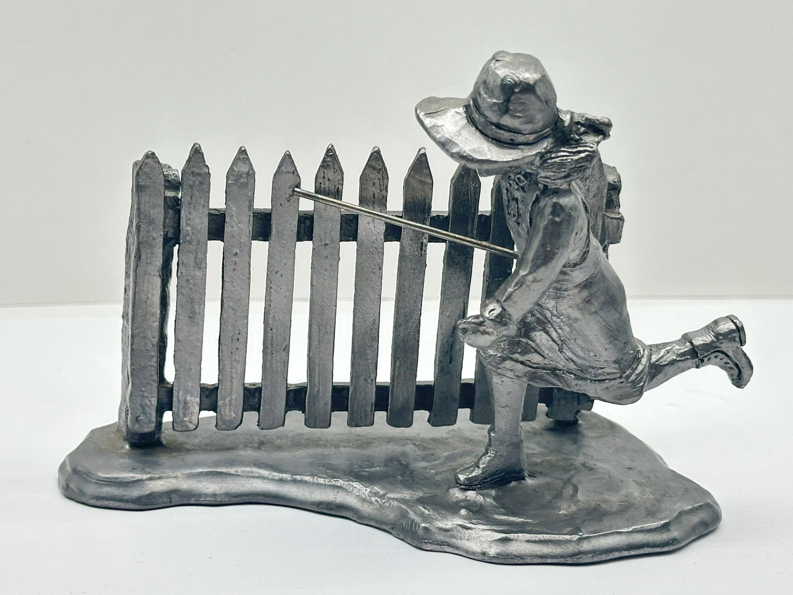 Very Large Vintage Michael Ricker Pewter 1005 Grams: vintage Michael Ricker pewter figurine depicting a girl running along a picket fence with a stick.
