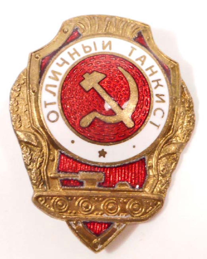 USSR SOVIET RUSSIAN TANK ARMORED BADGE: Measures 1 3/8" wide by 1 13/16" tall. The front has the Russian hammer & cycle in the center with a tank below. Has a screw mount post and nut on the reverse side. Maker marked. Stamped brass constru