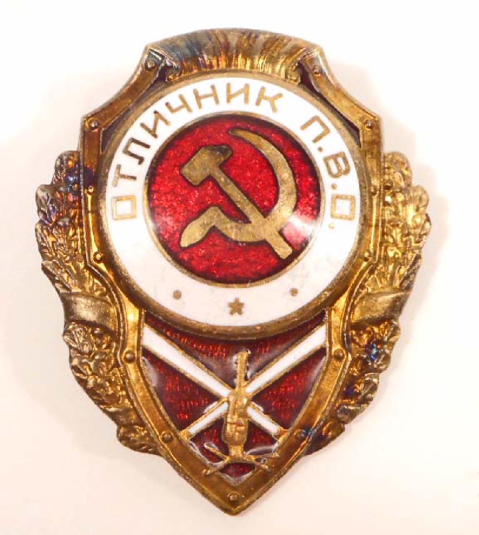 USSR SOVIET RUSSIAN FLAK ARTILLERY BADGE: Measures 1 3/8" wide by 1 13/16" tall. The front has the Russian hammer & cycle in the center with a flak gun below. Has a screw mount post and nut on the reverse side. Maker marked Stamped brass cons