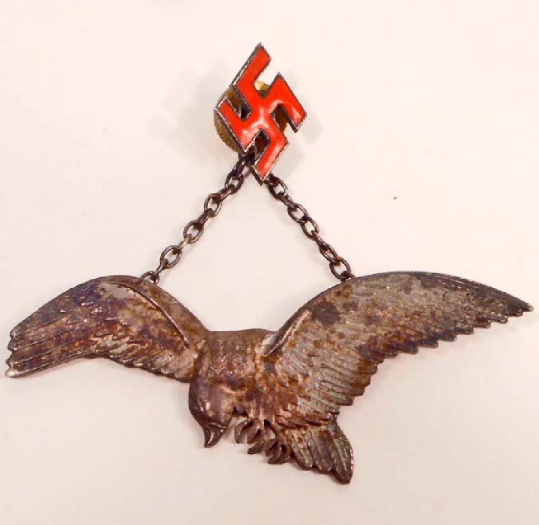 GERMAN NAZI POLISH LUFTWAFFE AXIS PILOT BADGE: Measures 3 1/8" wide by 1 3/16" tall. The front shows a flying eagle with a red enameled swastika attached to a chain above. Nickel construction.