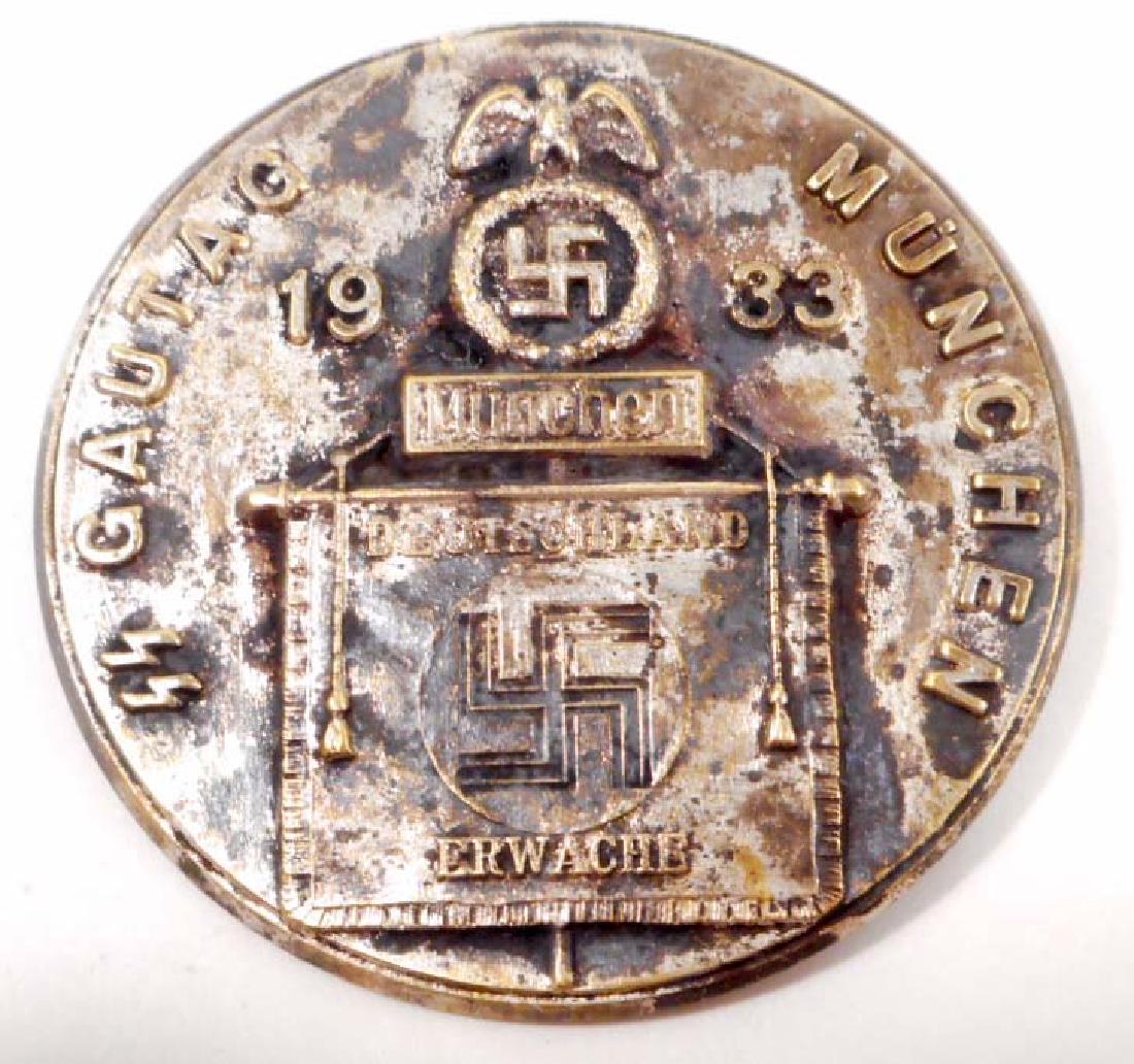 GERMAN NAZI WAFFEN SS GAU MUNCHEN TINNIE BADGE: Measures 1 13/16" in diameter. Has a thin horizontal pin back. Stamped nickel construction