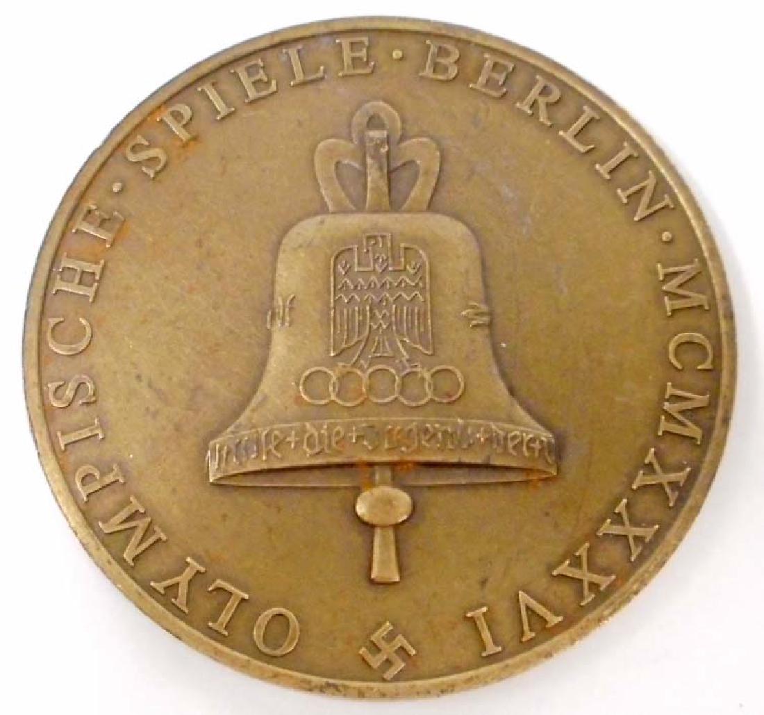GERMAN NAZI BRONZE BERLIN SUMMER OLYMPICS TABLE MEDAL: Measures 1 7/16" in diameter. The front shows a Greek Goddess holding a branch in One (1) hand and a wreath in the other. The reverse side shows the German WWII Olympic bell. Bronze construction