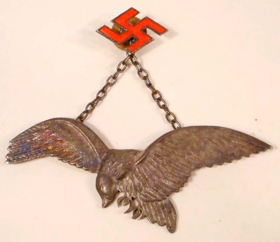 GERMAN POLISH NAZI LUFTWAFFE AXIS PILOT BADGE: Measures 3 3/16" wide by 1 1/4" tall. The front shows a flying eagle. Has a hanging chain with a red enameled swastika above. Has a screw mount post and nut on the reverse side. Nickel construction