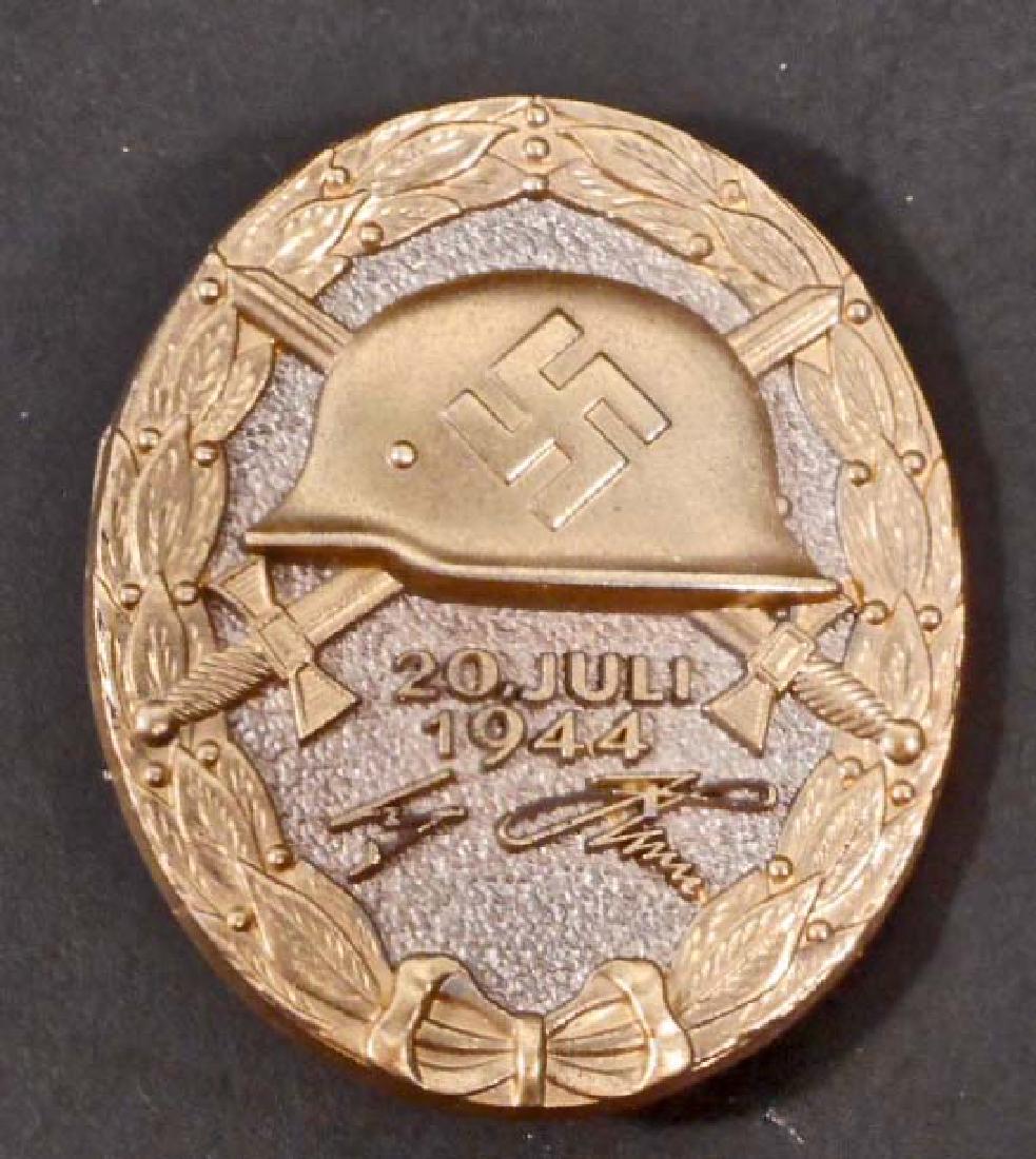 GERMAN NAZI GOLD JULY 20 1944 WOUND BADGE: The front shows a German helmet in the center with a pair of crossed swords in the back ground. Below reads '20 Juli 1944 Adolf Hitler'. The reverse side is marked '800 2'. Has a wide vertical pin bac