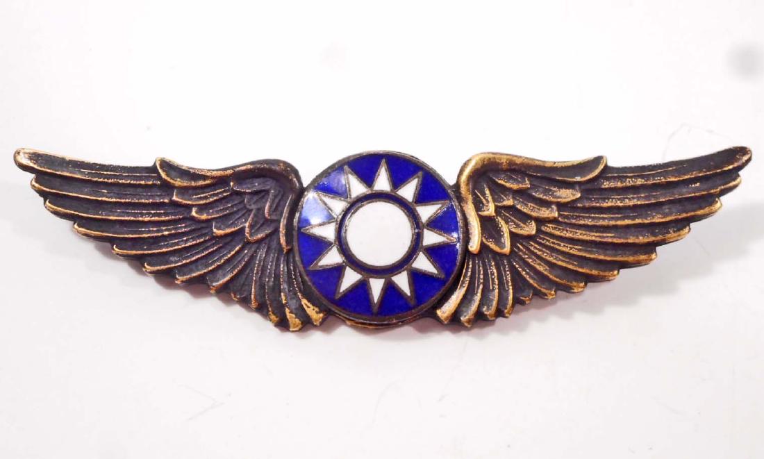 USAAF CHINA BURMA INDIA CHINESE CBI AVG PILOT WING: Measures 2 5/8" wide by 11/16" tall. The front shows the Chinese state star burst in the center flanked by a wing on each side. The reverse is numbered '501' and has Chinese writing above. Has a thin 