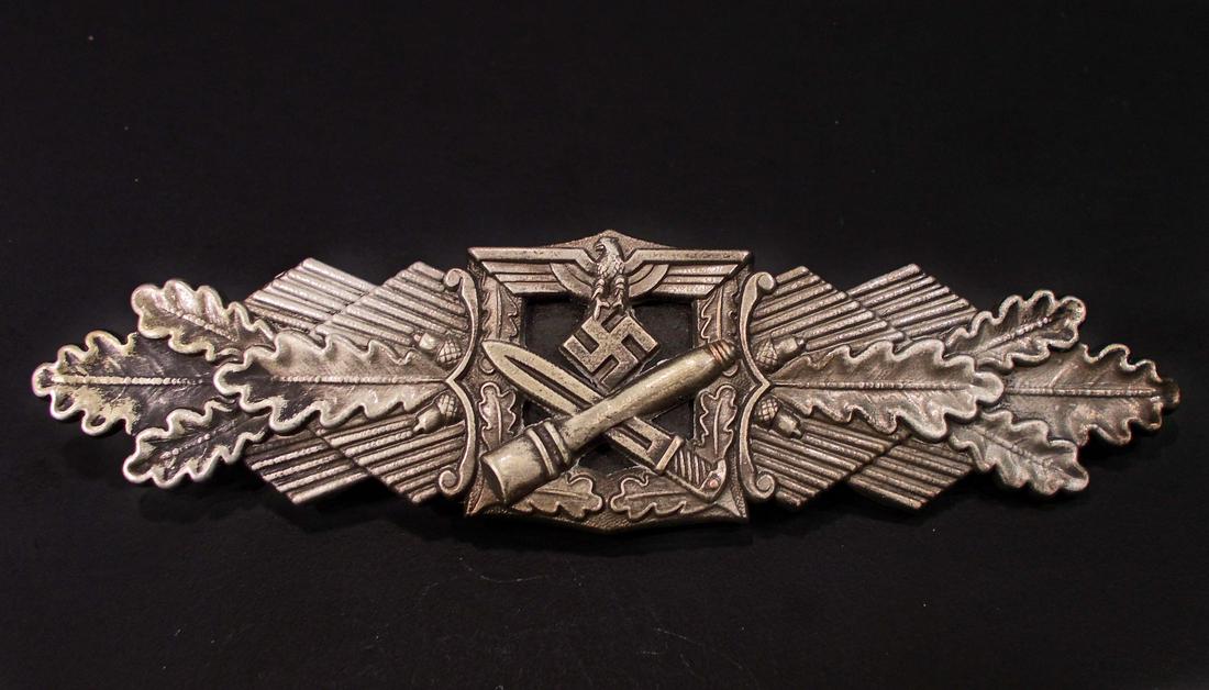 GERMAN NAZI ARMY SILVER CLOSE COMBAT CLASP: Front shows a German eagle with a crossed bayonet and stick grenade below. All Three (3) are flanded by oak leaves on each side. Reverse is maker marked Fec W E Peekhaus Berlin FLL. Has a wide horizon