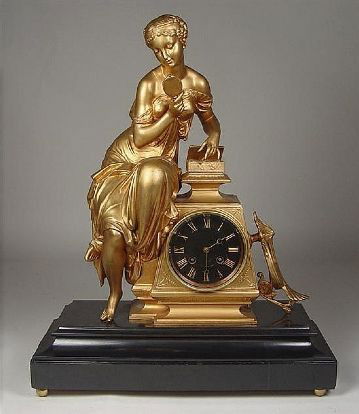 French Gilt Figural Clock Circa 1870.: French Gilt Figural Clock Circa 1870. Black enamel Roman dial with gilt numerals, in obelisk base with figure of maiden with mirror and dressing box. 20" x 16" x 7". FY186