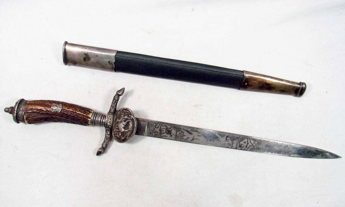 RARE GERMAN NAZI HUNTING CUTLASS DAGGER AND SCABBA: Approx 21" long overall. The blade is maker marked E & F Horster Solingen w/ their logo in the center. The blade is double engraved w/ a hunting motif. The stag antler handle has the DJ Hunting Associ