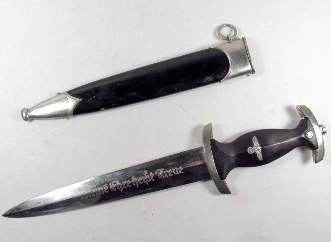 RARE GERMAN NAZI WAFFEN SS EM DAGGER W/ SCABBARD: Approx. 14.75" long overall. The blade is maker marked SS 121/34 RZM. The front of the blade reads Meine Ehre Heisst treue (My Honor is Loyalty). Has a very fine black ebony wood grip w/ nickel fittin