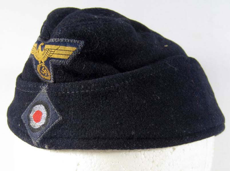 GERMAN NAZI NAVAL EM OVERSEAS CAP: Has a zig zag stitched bevo eagle and cockade on the front. The inside is maker marked RBN 18100 32544. Dark blue wool construction. For an enlisted man.