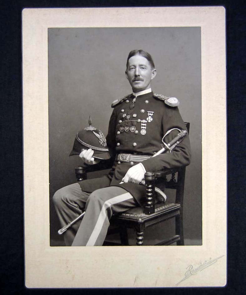 C. 1880'S MOUNTED PHOTO OF A US MILITARY SOLDIER IN: Great image of this soldier in his uniform. Shows all of his medals on the front of his uniform. He is also holding a Dressed Spike Helmet in one hand and a sword in the other. Approx. 5" by 7"