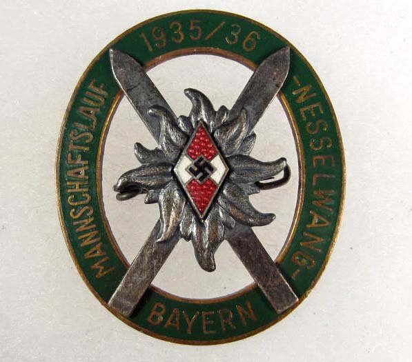 GERMAN NAZI HITLER YOUTH HJ 1936/36 ALPINE SKI BAD: Approx. 1.5" by 1.75". Maker marked H & Co Munchen. Pinback. Tow piece nickel brass and enameled w/ rivet construction.