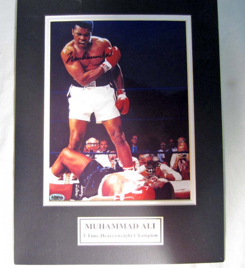 MUHAMMAD ALI AUTOGRAPHED PHOTO W/ COA: Approx. 10" by 13" matted photo. 3-Time Heavy Weight Champion. COA from Forensic Handwriting Examinations.