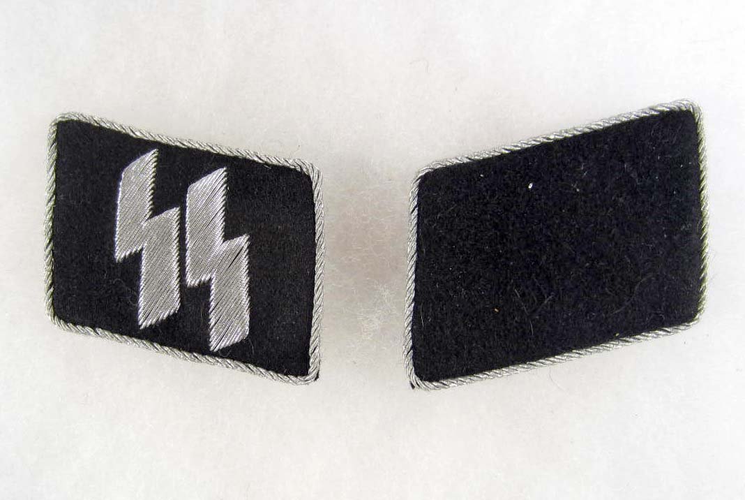 PAIR OF WAFFEN SS OFFICERS COLLAR TABS: Has a set of SS Silver bullion wire runics on one tab and is black on the other. Both have twisted silver bullion wire piping. Embroidered on a black wool backing.