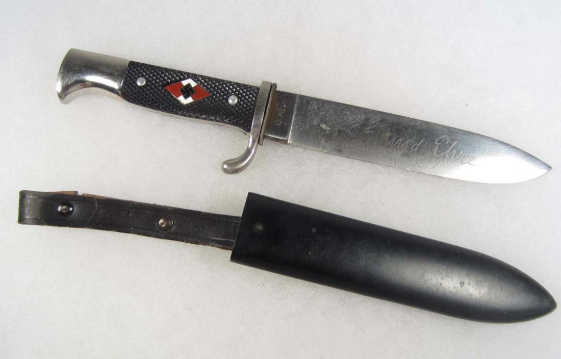 GERMAN NAZI HITLER YOUTH HJ KNIFE W/ SCABBARD: Approx. 10 1/16" long overall. The engraved steel blade reads Blut und Ehre (Blood and Honor). and is dated 1940. Has a black painted steel scabbard w/ the leather belt hanger.
