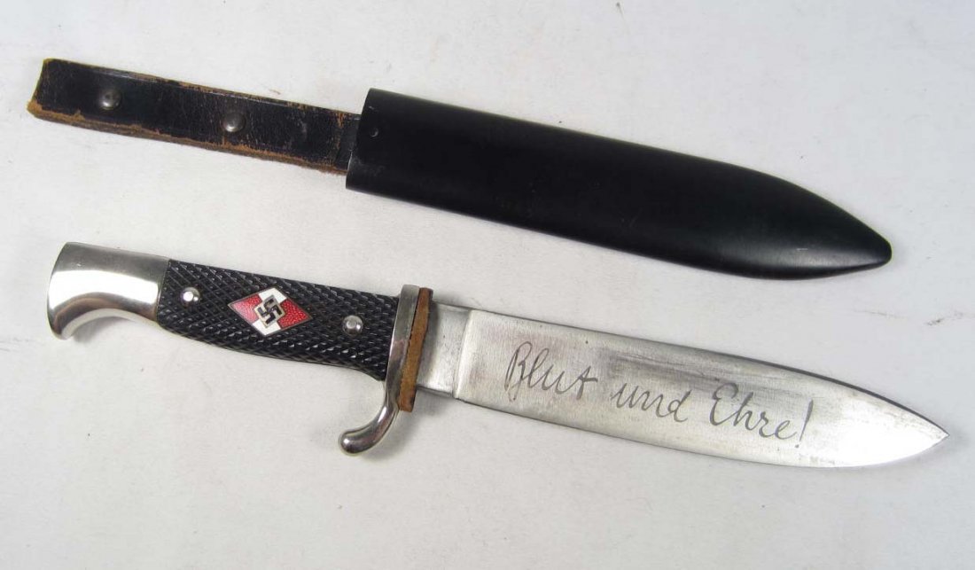 GERMAN NAZI HITLER YOUTH HJ KNIFE W/ SCABBARD: Approx. 10 1/8" long overall. The steel blade is etched and reads Blut und Ehre (Blood and Honor). Has a black painted steel scabbard w/ a black leather belt hanger attached. There is an enameled hitl