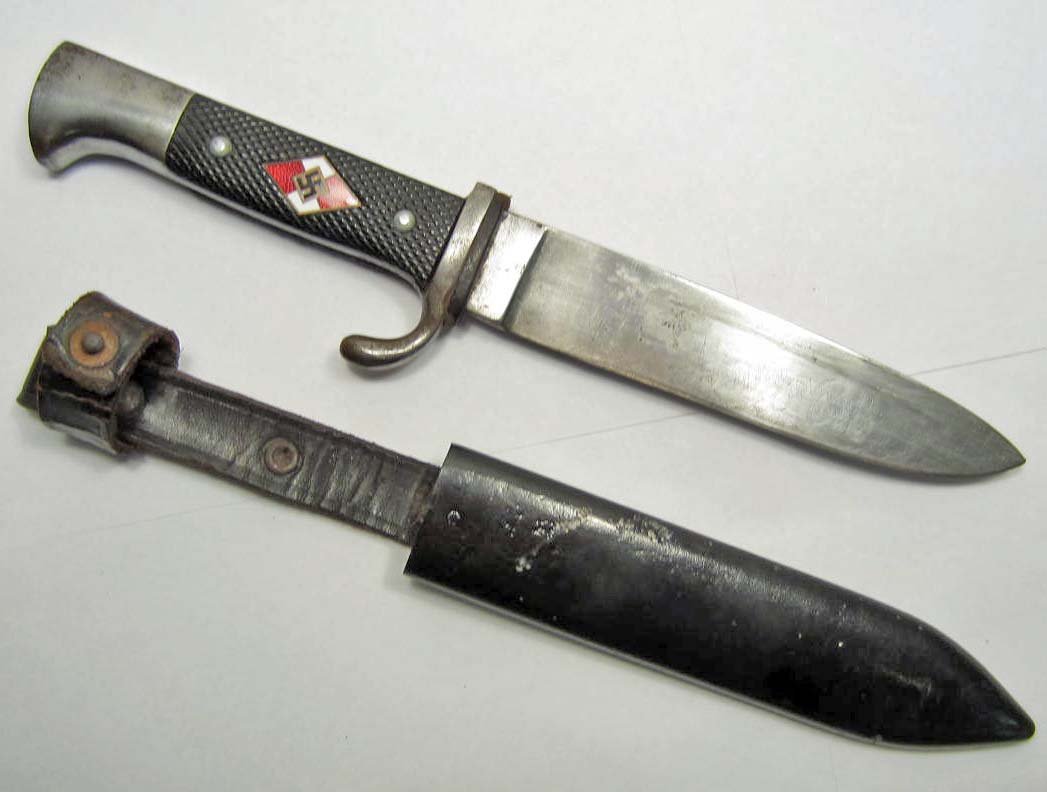 GERMAN NAZI HITLER YOUTH KNIFE W/ SCABBARD: Approx. 10.25" long overall. The steel blade is engraved Blut und Ehre. Has a black painted steel scabbard w/ a leather hanger. The HJ enamled diamond is inset into the handle.