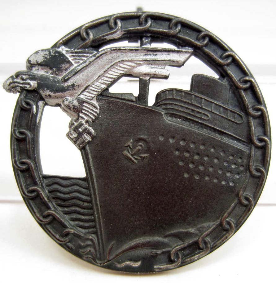 GERMAN NAZI NAVAL BLOCKADE RUNNER BADGE: Has a wide vertical pinback. maker marked Fec Otto Placzek Ausf Schwerin Berlin. Nickel construction.