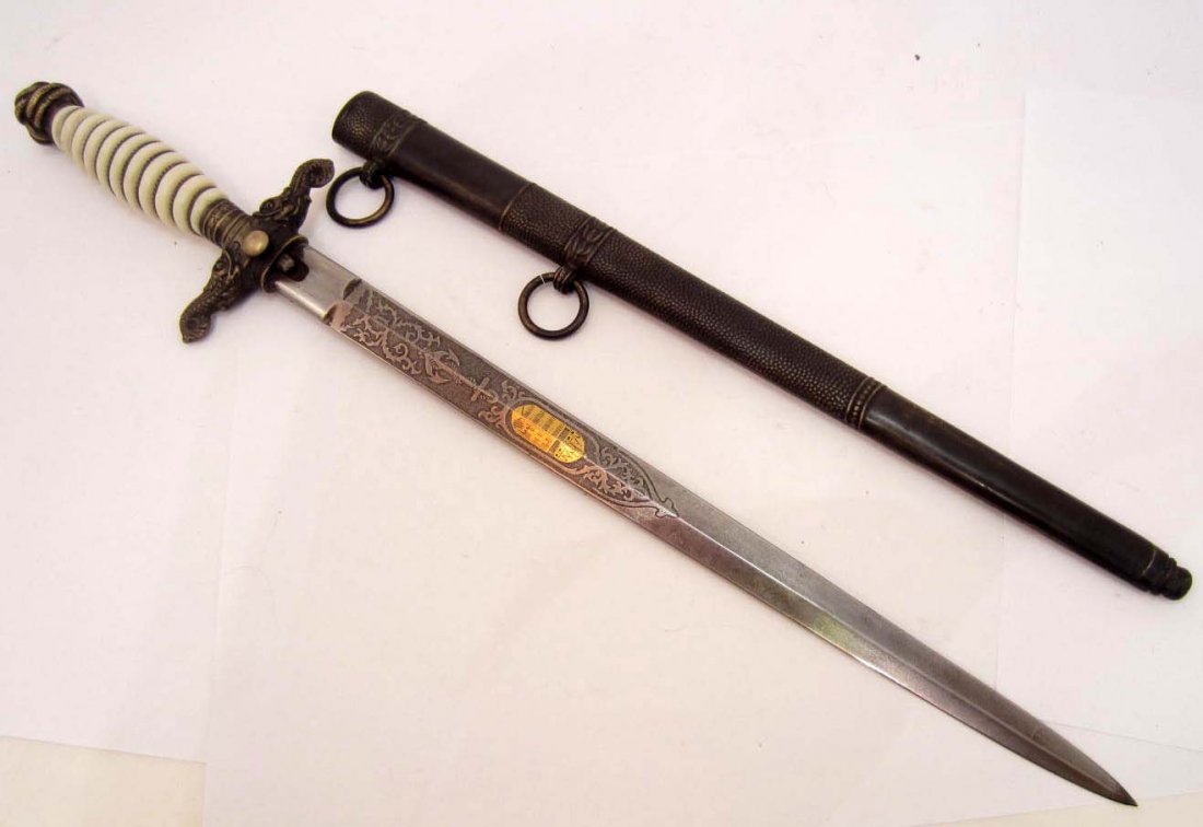 IMPERIAL HUNGARIAN NAVY OFFICERS DAGGER W/ SCABBARD: Approx. 16.5" long overall. Etched steel blade is approx. 3/4" wide by 11 1/16" long. shows a naval motif w/ anchors and a floral design. There is also a gilt coat of arms in the center. it is maker m