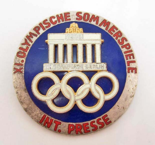 GERMAN NAZI BERLIN OLYMPICS INTERNATIONAL PRESS BADGE: Pinback. Approx. 1 13/16" diameter. maker marked Rob Neff Berling W 57. Two piece nickel and brass construction. has red white and blue enamel. Difficult to find.