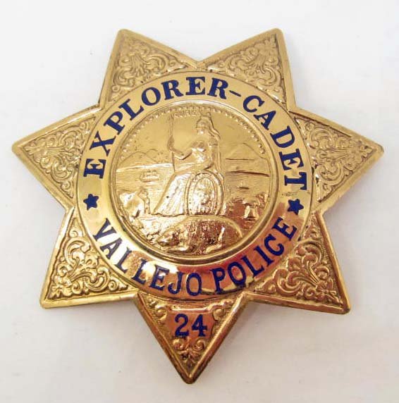 VINTAGE VALLEJO CA. POLICE EXPLORER CADET #24 LAW BADGE: Approx. 2 3/8" diameter. Has a thin vertical pinback. The front reads Explorer - Cadet Vallejo Police #24 and has the California State Seal in the center. Two piece brass construction w/ blue enamel. 