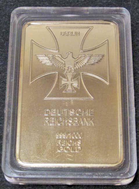 NOVELTY POST GERMA N NAZI DEUTSCHE REICHBANK GOLD BAR: Approx. 1 1/8" by 1 3/4". Front reads Deutsche Reichbank 999/1000 Reichs Gold. There is a German eagle holding an Iron Cross w/ Berlin above. The reverse side reads Fuhrer Und Reichkanzler Adolf Hitle