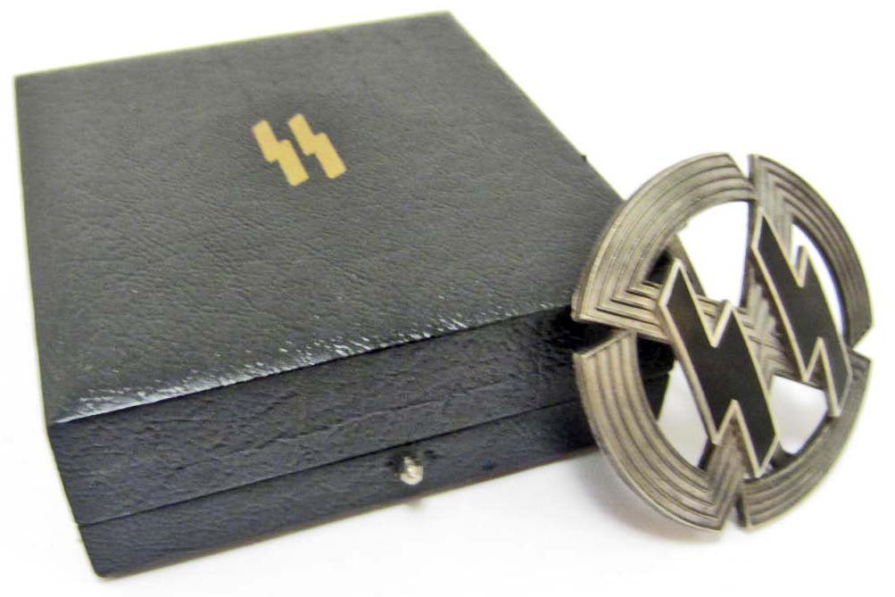 CASED GERMAN NAZI WAFFEN SS SILVER RUNIC SPORTS BADGE: Has a wide vertical pin back. Maker marked Richard Sieper & Sohne - Ludenscheid RZM M1/25. Has a pair of SS black enameled lightning bolts in the center. The award case measures 3 1/8" wide by 3 3/8" 