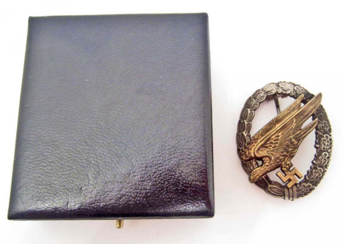 CASED GERMAN LUFTWAFFE PARATROOPER FALLSHIRMJAGER JUMP: Maker marked B & N L. Has a thin vertical pin back. Two piece two domed rivet nickel & brass construction. Includes the presentation case. The dark blue leatherette case measures 3 1/16" wide by 3 3/8