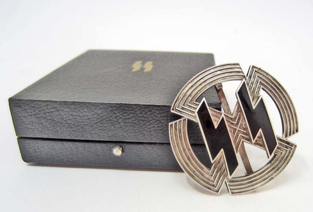 CASED GERMAN NAZI SILVER WAFFEN SS RUNIC BADGE: Has a wide vertical pin back. The reverse is maker marked Richard Sieper & Sohne Ludenscheid RZM M1/25. The black leatherette case measures 3 3/16" wide by 3 7/16" long by 1 ¼" tall. Has a pair of gi
