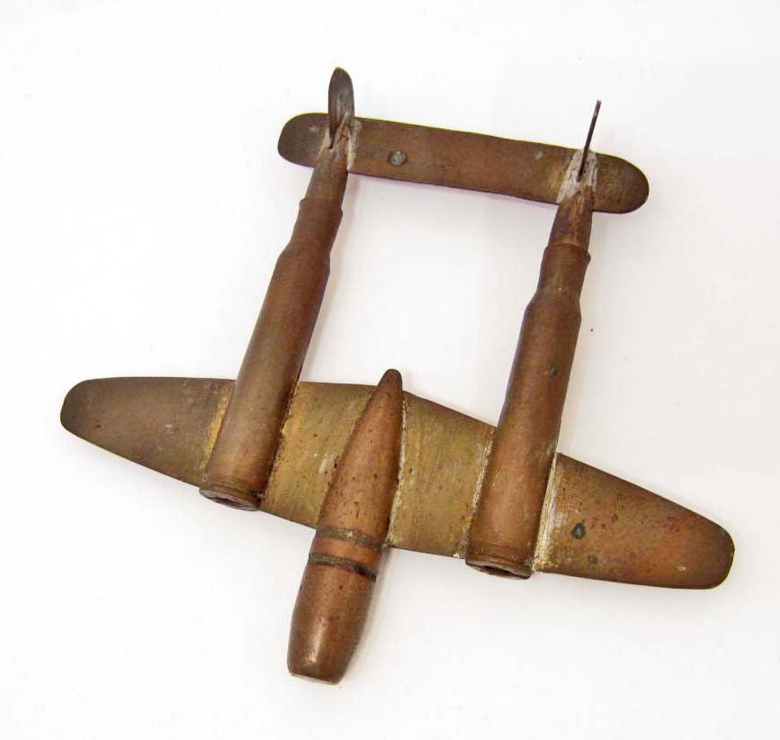 USAAF ARMY AIR CORPS TRENCH ART P-38 FIGHTER AIRPLANE: Measures 5 1/8" wide by 4 3/4" long. Soldiered brass bullet construction. Assembled by a Prisoner of War in a prison camp.