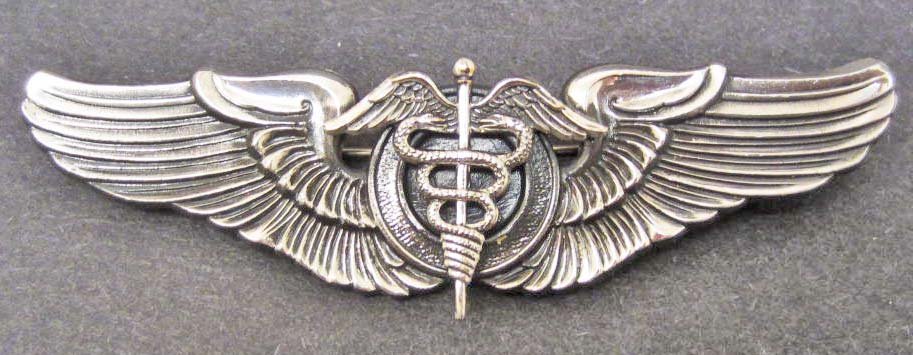 USAAF ARMY AIR CORPS FLIGHT SURGEON WING: Measures 3 1/16" wide by 15/16" tall. The reverse is maker marked NS Meyer New York. Has a thin horizontal pin back with a locking catch. Two piece nickel construction.