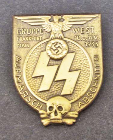 GERMAN NAZI WAFFEN SS FRANKFURT RALLY BADGE: Measures 1 7/16" wide by 1 3/4" tall. Has a thin horizontal pin back. Shows a Nazi eagle at the top, SS runics in the center and a skull at the base. Die struck stamped brass construction