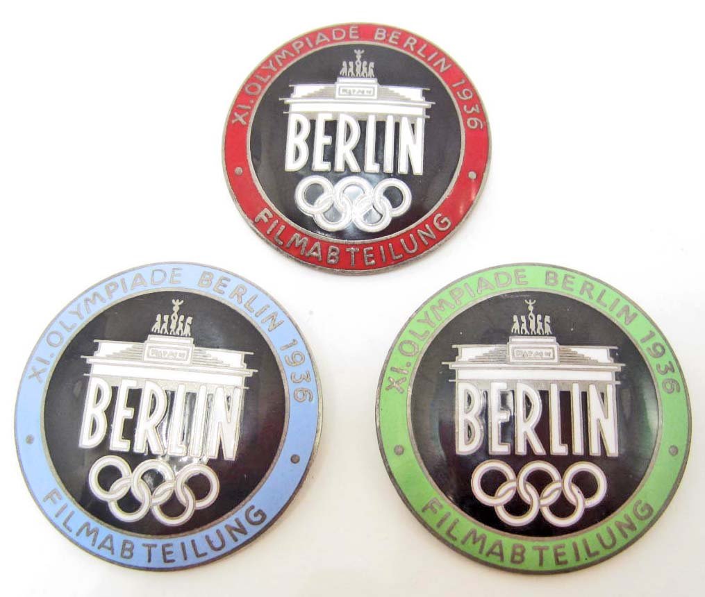 LOT OF 3 GERMAN NAZI BERLIN OLYMPICS FILM MAKER BADGES: The measure 1 9/16" in diameter. All are maker marked Rob Neff Berlin W 57. They have a thin horizontal pin back. Nickel construction with enamel.