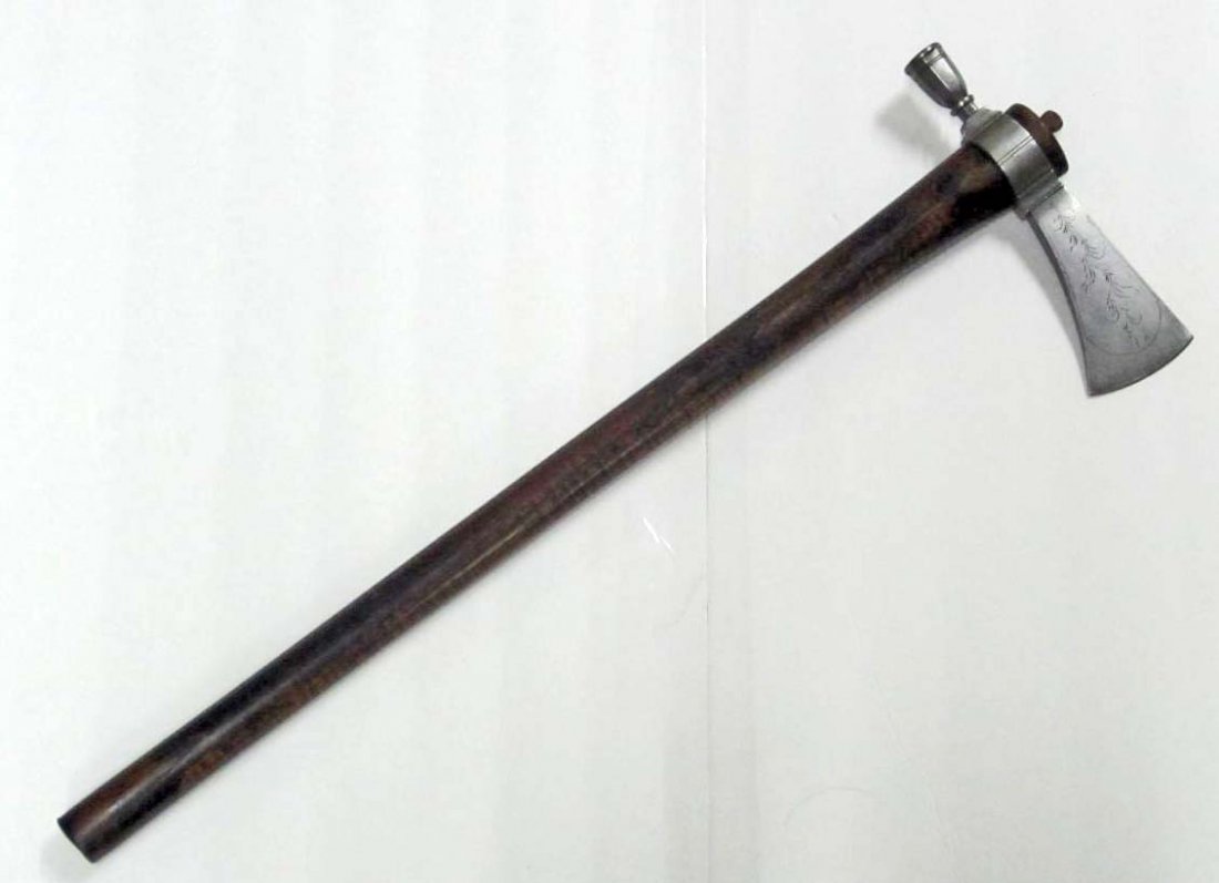 COWBOY ERA PEACE PIPE AXE W/ WOOD HANDLE: The handle measures 26 1/8" long overall and 1 1/8" in diameter. The iron axe head is hand engraved with swirls. It measures 2 11/16" tall by 8 3/4" wide.