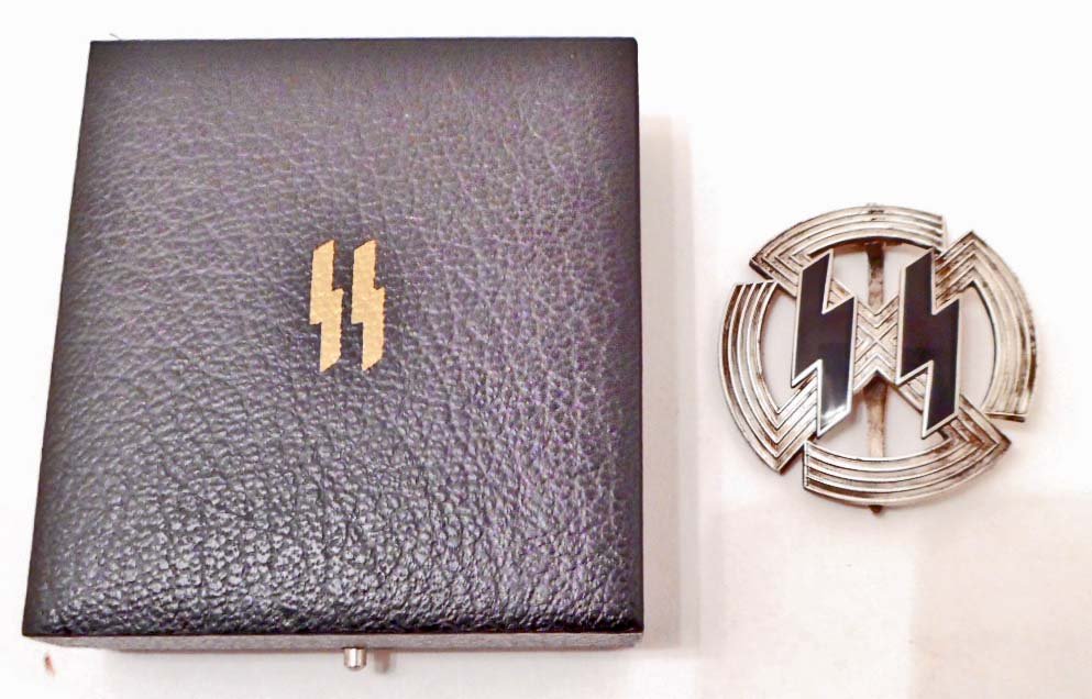 GERMAN NAZI CASED WAFFEN SS SILVER RUNIC BADGE: The reverse side is maker marked Richard Sieper & Sohne Ludenscheid RZM M1/25. Has a wide vertical pin back. Three piece construction with a pair of black enameled ruins in the center. The black prese