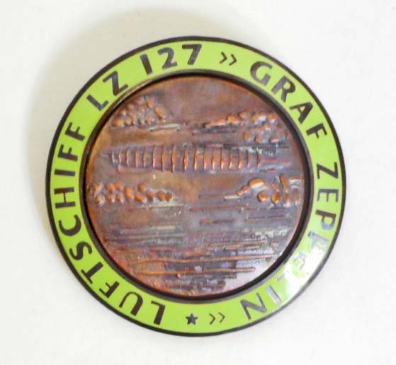 GERMAN NAZI GRAF ZEPPELIN LUFTSCHIFF LZ 127 AIR SHIP: Measures 1 3/4" in diameter. The reverse is maker marked 'FLL'. Has a thin horizontal pin back. Two piece copper construction with lime green enamel.