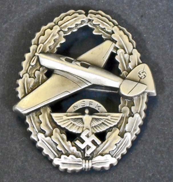 GERMAN NAZI PRE LUFTWAFFE NSFK GLIDER KORPS PILOT BADGE: The reverse side is maker marked 'ges gesch 22639'. Has a wide horizontal pin back. Stamped nickel construction.