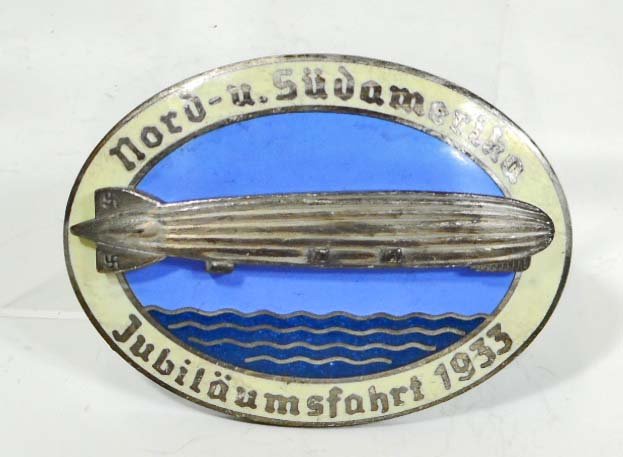 GERMAN NAZI GRA ZEPPELIN AIR SHIP COMMEMORATIVE LIGHT: Measures 2" wide by 1 1/2" tall. The reverse side is maker marked 'Kerbach Dresden'. Has a thin horizontal pin back. Two piece nickel construction with blue and beige enamel